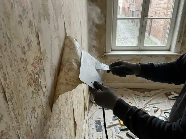 Oud behang wordt met stoom van de muur gehaald
